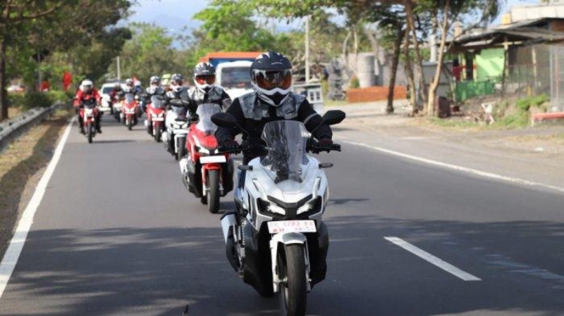 Pengendara motor melakukan peregangan saat istirahat Touring Lintas Kota